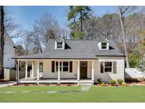 Charming home featuring a covered front porch, two dormers, and manicured lawn at 1861 Dyer Cir, Atlanta, GA 30341