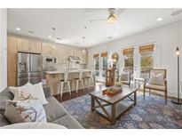 Open-concept living room with a modern kitchen, stainless steel appliances, and access to a balcony at 305 Canton Way, Roswell, GA 30075