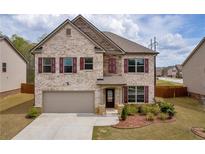 Charming two-story home with brick facade, landscaped yard, and attached two-car garage at 509 Azalea Bloom Dr, Loganville, GA 30052