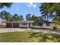 Charming ranch home featuring a well-manicured lawn and a two-car garage at 1025 Martins Lake Close, Roswell, GA 30076