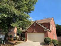 Charming two-story brick home with an attached two-car garage and mature landscaping in a suburban neighborhood at 3259 S Pointe Ct, Atlanta, GA 30340