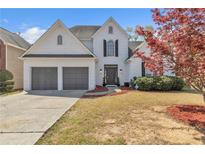 Charming two-story home with a two-car garage and a well-maintained front yard at 1055 Crabapple Parc Dr, Roswell, GA 30076