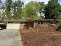 Charming brick ranch home with a carport and well-maintained front yard at 3712 Spring Hill Se Rd, Smyrna, GA 30080