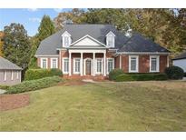 Inviting two-story brick home featuring a symmetrical facade, stately columns, and a well-manicured lawn at 4385 Old Hamilton Mill Rd, Buford, GA 30518