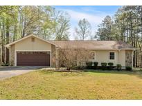 Charming single-story home featuring a two-car garage and a well-maintained front lawn at 4670 Sundridge Trl, Fairburn, GA 30213