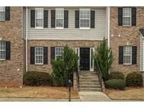 Charming multi-story townhouse with brick facade, gray siding, and black shutters at 5980 Eagle Tiff Ln, Sugar Hill, GA 30518