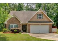 Charming single-Gathering home featuring a brick facade, attached two-car garage and well-manicured front lawn at 8166 N Pine Cone Dr, Villa Rica, GA 30180