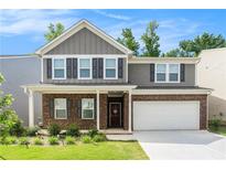 Charming two-story home with a brick facade, gray siding, and a well-manicured front lawn at 400 Paulownia Cir, Mcdonough, GA 30253