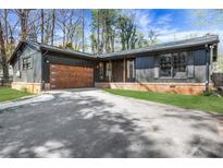 Charming one-story home featuring a wooden garage door and a well-maintained front yard at 3650 Dogwood Farm Rd, Decatur, GA 30034