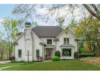 Stunning two-story home with a brick facade, well-manicured lawn, and mature trees creating a picturesque curb appeal at 730 Denmead Se Ml, Marietta, GA 30067