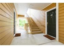 Building exterior featuring wood siding, staircase and entry doors with welcome mats at 225 Bentley Pl, Tucker, GA 30084