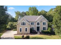 Charming two-story home with a well-manicured lawn and mature trees offers great curb appeal at 915 Summer Wind Pl, Roswell, GA 30075