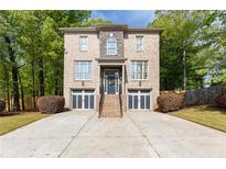 Traditional two-story brick home featuring a two-car garage and professionally landscaped front yard at 3110 Dickson Ne St, Brookhaven, GA 30319