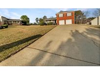 Two-story red brick house with a two-car garage and a large front yard at 5211 Benjamin Trl, Ellenwood, GA 30294