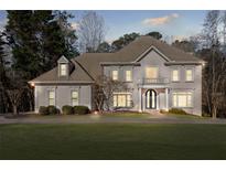 Stately two-story home with a lush green lawn and mature trees offering a serene and inviting curb appeal at 8610 Sentinae Chase Dr, Roswell, GA 30076