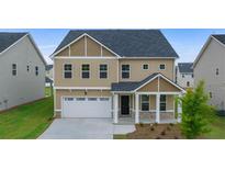 Charming two-story home with a welcoming front porch and a two-car garage at 13562 Whitman Ln, Covington, GA 30014