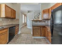 Traditional kitchen with oak cabinets and black appliances near a staircase with white railings at 1124 Lawton Sw Pl, Atlanta, GA 30310