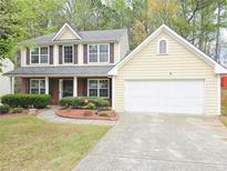 Charming two-story home with a well-maintained front lawn and attached two car garage at 1972 Ashwood Grove Dr, Snellville, GA 30078