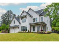 Beautiful two-story white brick home with a well-manicured lawn and a two car garage at 1011 Ridgeview Rd, Woodstock, GA 30188