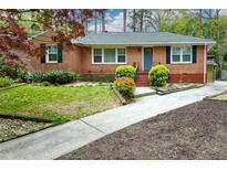 Charming brick home with a well-manicured front yard and a quaint blue front door at 1245 Briar Hills Ne Dr, Atlanta, GA 30306