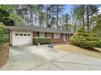 Charming brick ranch-style home featuring a well-manicured lawn and attached garage at 3200 W Roxboro Rd, Atlanta, GA 30324