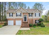 Charming two-story home with brick accents, a two-car garage, and manicured landscaping at 1160 Chateau Ter, Mcdonough, GA 30253