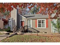 Charming home featuring a chimney, red door, and orange shutters complemented by a lush, landscaped yard in the fall at 7020 Panda Ln, Austell, GA 30168