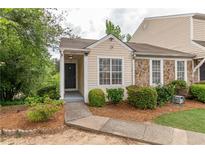 Charming townhouse exterior with stone accents, inviting front porch, and landscaped walkway at 3987 Bayside Cir, Atlanta, GA 30340