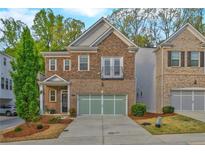 Two-story home featuring a brick and stone exterior, two car garage, and well maintained landscaping at 1098 Central Park Rd, Decatur, GA 30033