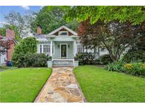 Charming home featuring a stone walkway leading to the covered porch and manicured lawn at 638 Cooledge Ne Ave, Atlanta, GA 30306