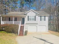 Charming home with a two-car garage, front porch, and mature landscaping at 120 Grove Ln, Temple, GA 30179