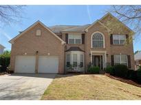 Charming two-story brick home with a well-manicured lawn, attached two car garage, and inviting front entrance at 2688 Autumn Ridge Ln, Lawrenceville, GA 30044