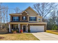Charming two-story home with a well-maintained lawn, brick facade, and inviting front porch at 4870 Odum View Ln, Cumming, GA 30040