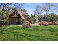 Expansive backyard featuring a stone patio with an outdoor dining area and a covered porch at 710 E Northway Ln, Atlanta, GA 30342