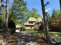 Charming two-story home featuring manicured landscaping, mature trees and a private drive at 710 E Northway Ln, Atlanta, GA 30342