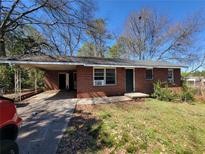 Red brick single-story home with a covered carport and small front yard at 103 Woodhaven Dr, Stockbridge, GA 30281