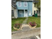 Charming townhouse with a walkway surrounded by beautiful flower beds leading to the front door at 2391 Cove Rd, Lithonia, GA 30058