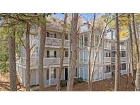 Gray two-story condo with white trim, multiple balconies and wooden stairs at 409 Natchez Trce, Sandy Springs, GA 30350