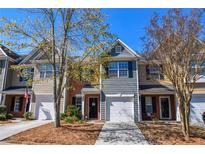Charming two-story townhome with well-maintained landscaping and a one-car garage, perfect for comfortable living at 904 Magnolia Leaf Dr, Woodstock, GA 30188
