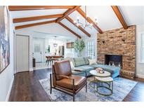 Inviting living room with vaulted ceilings, exposed beams, brick fireplace, and hardwood floors at 5925 Old Bill Cook Rd, South Fulton, GA 30349