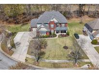 Expansive aerial view of a brick two-story home, landscaped front yard, and wide driveway at 7090 Blue Sky Drive, Locust Grove, GA 30248
