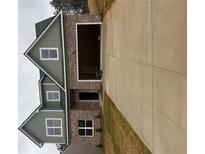 Two-story home featuring a brick facade, a gray exterior, an attached garage and a long concrete driveway at 793 Rock Hill Pkwy, Lithia Springs, GA 30122