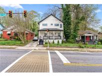 Street view showcasing a two-story home with a welcoming front porch and manicured lawn in a neighborhood setting at 1115 Martin Luther King Jr Sw Dr, Atlanta, GA 30314