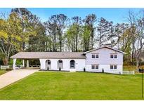 Charming two-story home with a spacious front yard, covered car port, and eye-catching arched facade at 2876 Wendwood Dr, Marietta, GA 30062