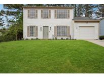 Charming two-story home with a lush green lawn and a quaint, welcoming facade and attached garage at 6244 Marbut Farms Trl, Lithonia, GA 30058