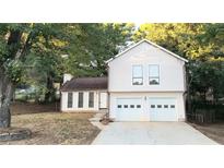 Charming two-story home featuring a two-car garage and a well-maintained front yard with mature trees at 849 Cadet Nw Ct, Lilburn, GA 30047