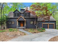 Charming two-story home featuring a dark exterior and complemented by lush greenery at 1890 Spalding Dr, Atlanta, GA 30350
