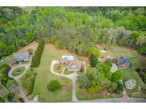 Expansive property featuring a home, pool, and lush greenery, offering privacy and space at 5040 Fawn Valley Dr, Loganville, GA 30052
