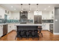 Bright kitchen with a large island, stainless steel appliances, and a mosaic tile backsplash at 708 Mcgill Ne Pl, Atlanta, GA 30312