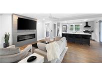 Bright, open-concept living room boasts a modern fireplace, large TV, and seamless flow to the kitchen and breakfast bar at 1251 Pierce Se Ave, Smyrna, GA 30080